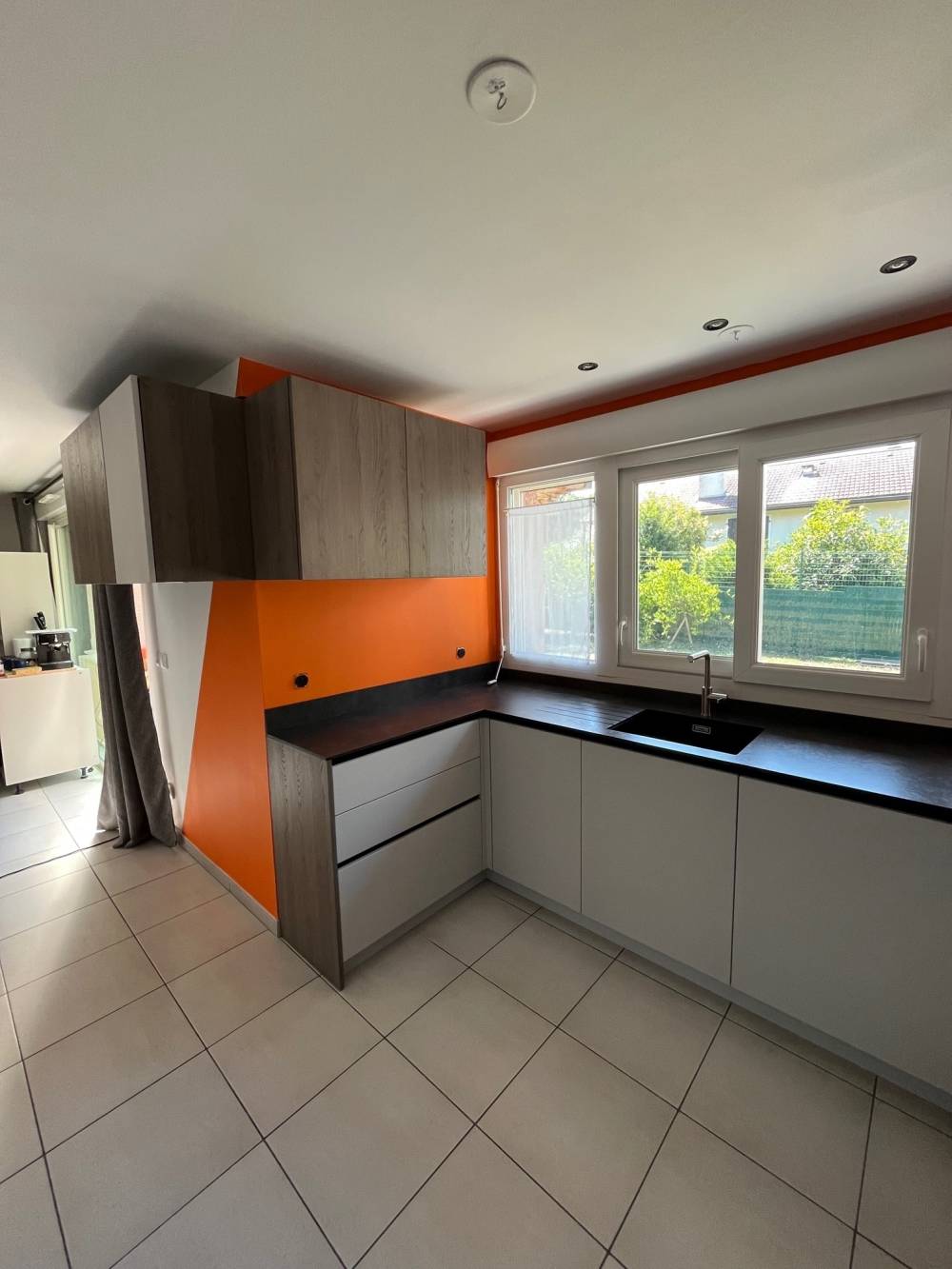 Cuisine angle grise bois mur orange plan noir fenêtre — Mood Inside, agenceur à Annecy