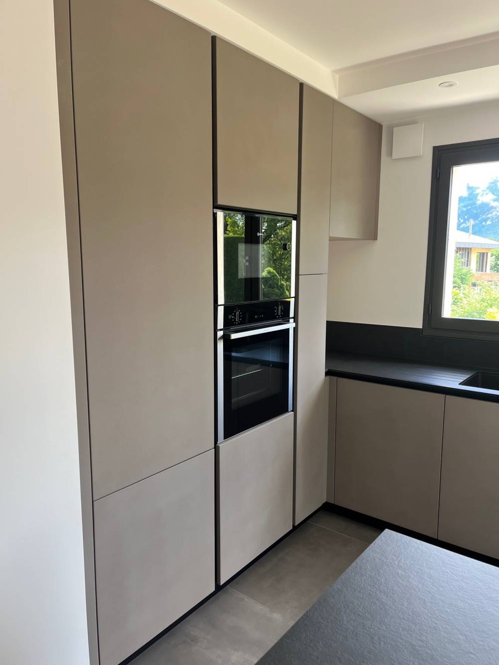 Cuisine colonnes grises fours encastrés plan noir — Mood Inside, agenceur à Annecy