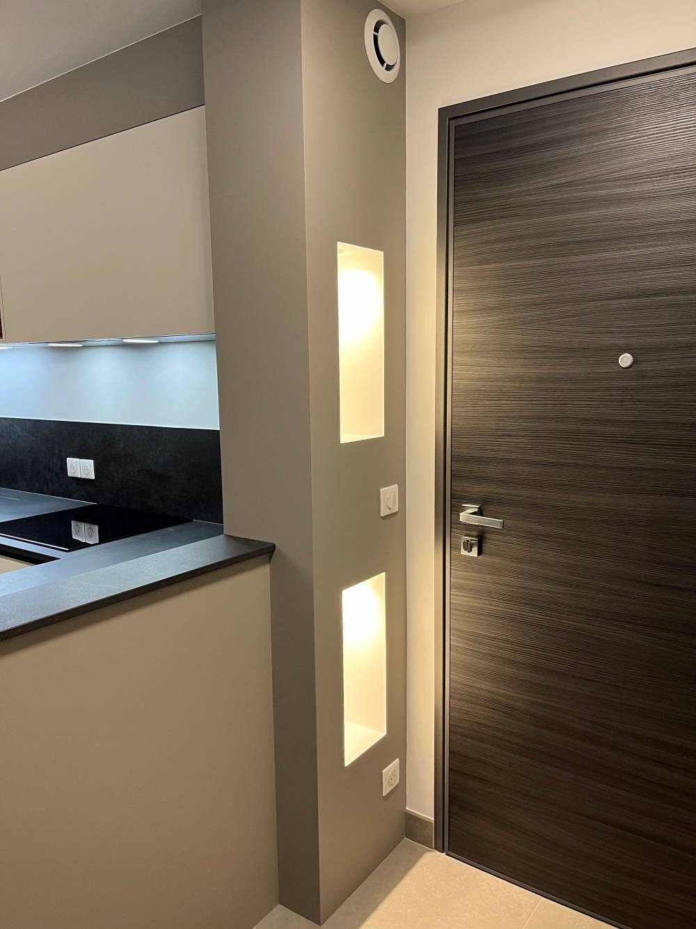 Cuisine taupe niches lumineuses porte bois foncé — Mood Inside, agenceur à Annecy