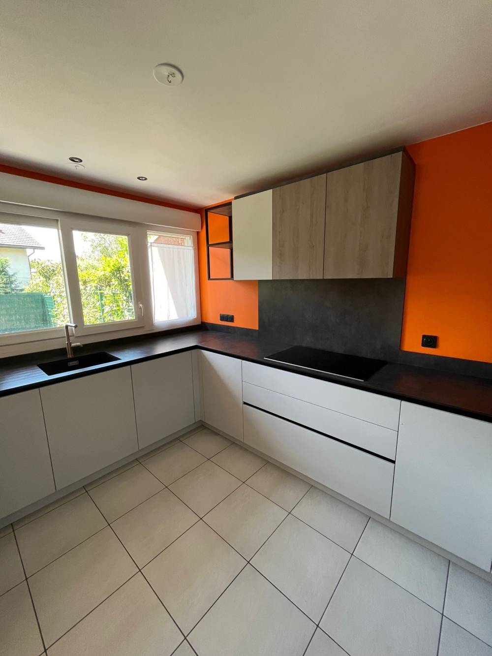Cuisine en U grise bois mur orange plan noir — Mood Inside, agenceur à Annecy