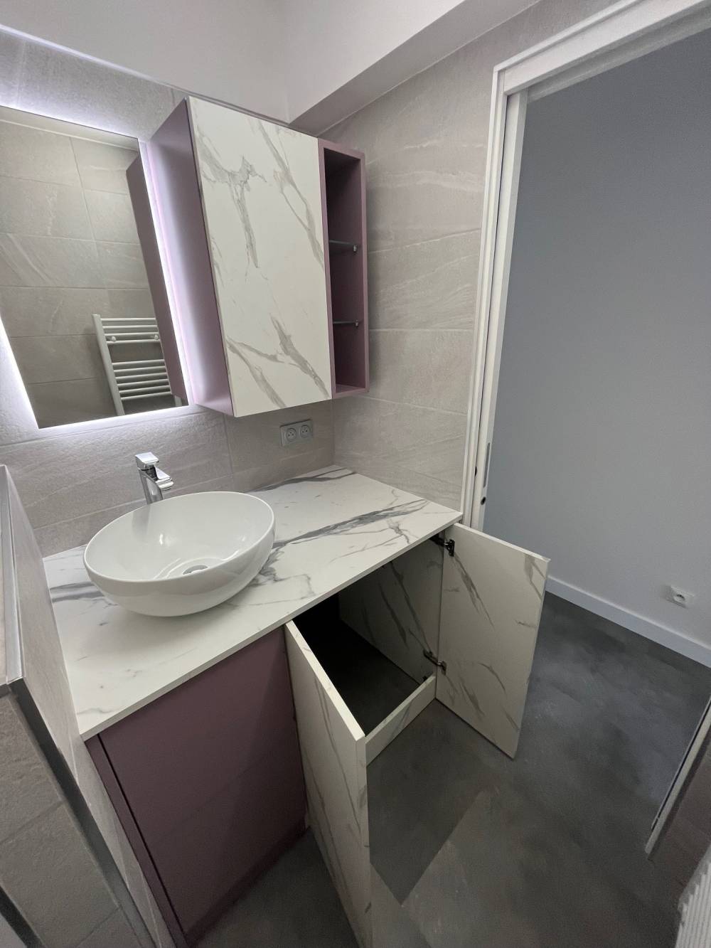 Salle de bain effet marbre porte ouverte panier linge — Mood Inside, agenceur à Annecy